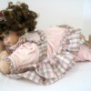 Identifying a Porcelain Doll - doll in pink and plaid outfit lying down