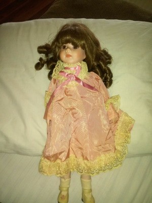 Value of a Brinn Porcelain Doll - dark haired doll wearing a pink lace trimmed outfit