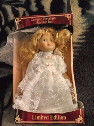 Value of a Porcelain Doll - unidentified doll in a box, wearing a white lace trimmed dress
