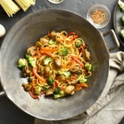 A wok with stir fried noodles and vegetables.