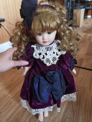 Identifying Porcelain Dolls - doll with ringlets wearing a plum colored dress with white lace trim