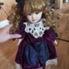 Identifying Porcelain Dolls - doll with ringlets wearing a plum colored dress with white lace trim