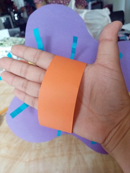 Making a Paper Butterfly Puppet - child's hand through the paper loop