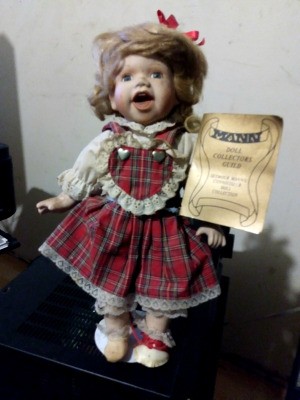 Value of a Seymour Mann Porcelain Doll - doll wearing a red plaid dress holding a certificate
