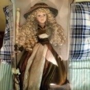 Value of a Collector's Choice Porcelain Doll - blond doll with very long ringlets, wearing a brown and cream dress and holding perhaps a twig broom