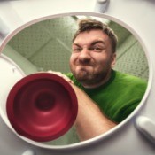 A man using a toilet plunger.