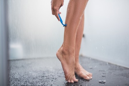 Woman Shaving Her Legs with Body Lotion