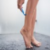 Woman Shaving Her Legs with Body Lotion