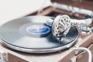 An antique phonograph playing a small record.