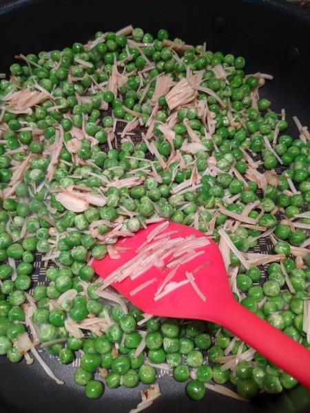 peas added to mushrooms in pan