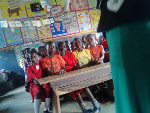 Finding an Agency to Help with Free School Desks in Uganda - children at a long crowded desk