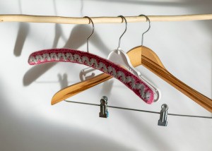 A collection of hangers with the front one being covered in yarn.