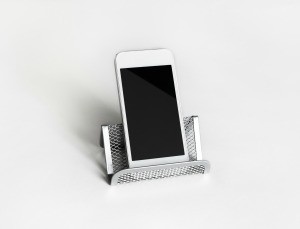 A business card holder being used as a cell phone stand.