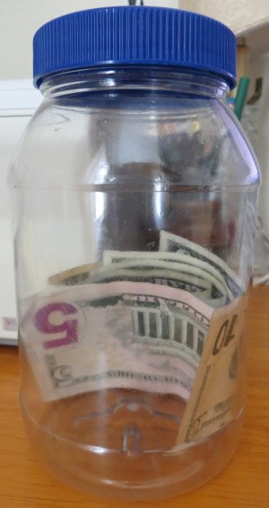 Money in a recycled plastic mayo jar.