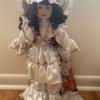 Identifying a Porcelain Doll - doll wearing a long white dress with a floral train and white hat