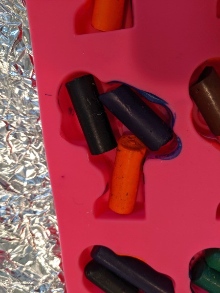 Melted Crayon as Halloween Favors - closeup showing how to fit the pieces in the shaped pan