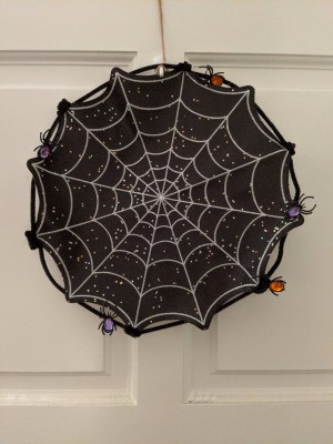 Halloween Spiderweb Placemat Wreath - finished wreath hanging on a door