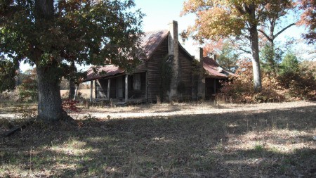 An old house surrounded by trees.