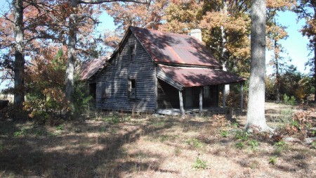 An old house surrounded by trees.