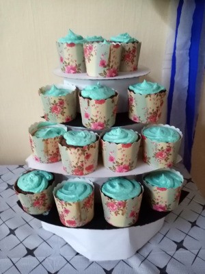 DIY 4 Tier Cupcake Stand - blue frosted cupcakes with floral paper wrappings on the stand for the party