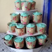 DIY 4 Tier Cupcake Stand - blue frosted cupcakes with floral paper wrappings on the stand for the party