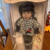 Value of a Collector's Choice Porcelain Doll - doll in box wearing a houndstooth jacket