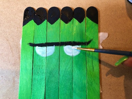 Halloween Craft Stick Puzzles - two white half circles below the brow for eyes, allow to dry