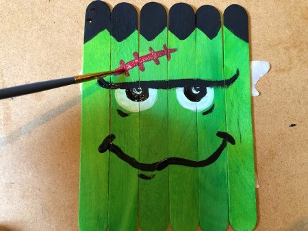 Halloween Craft Stick Puzzles - paint red stitches on his forehead