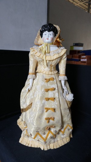 Identifying a Porcelain Doll - very old style porcelain doll in long beige dress with matching bonnet