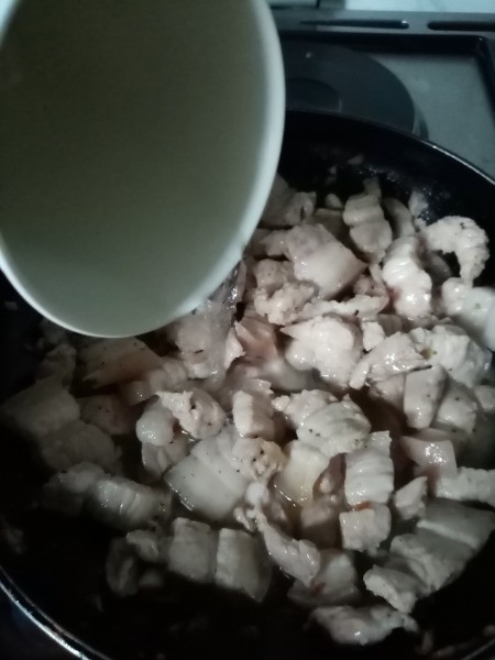 adding water to Pork in pan