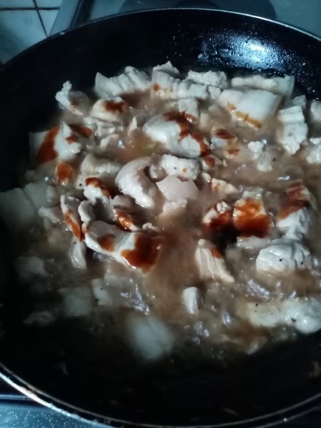 adding oyster sauce to Pork in pan