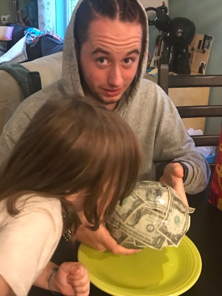 Cold Hard Cash Gift - brother with raised eye brows as younger brother looks on