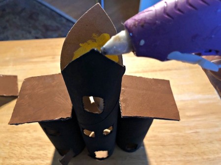 Cardboard Tube Haunted House - add glue to the tops of the tubes and glue the roofs in place