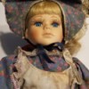 Value of a Goldenvale Collection Doll - doll wearing a floral print dress with tan pinafore and matching floral head scarf