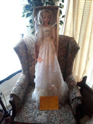Finding the Value of Ashley Belle Dolls - tall doll wearing a long white dress standing in the box on a chair