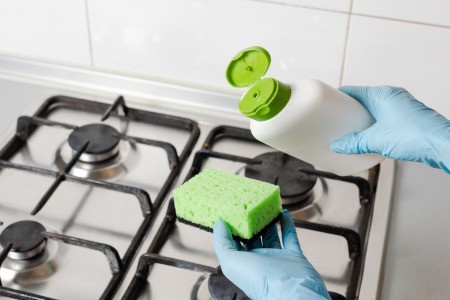 Cleaning gas burners with a sponge.