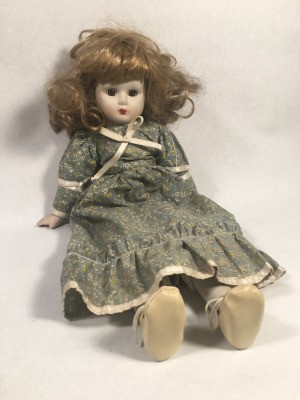 Identifying a Porcelain Doll - doll with mussed up hair wearing a long print dress