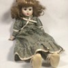 Identifying a Porcelain Doll - doll with mussed up hair wearing a long print dress