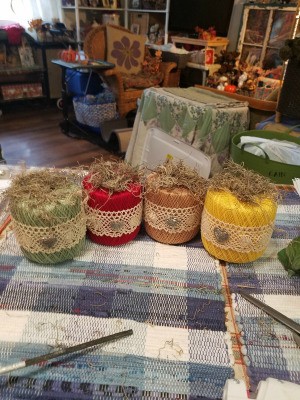 Crochet Thread Spool Pumpkins - the four finished pumpkins sitting on a tablecloth