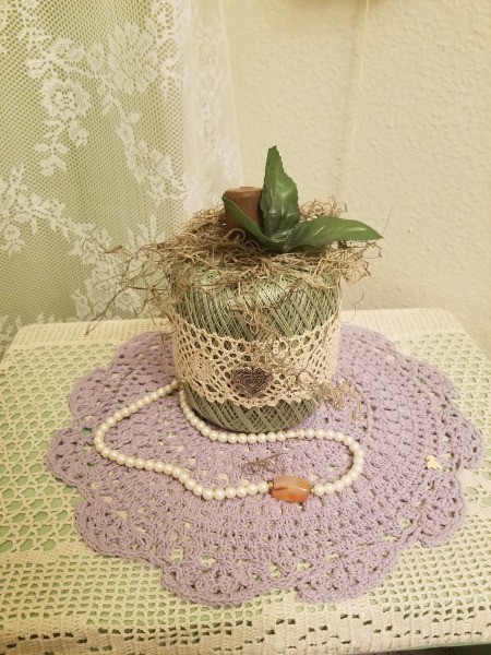 Crochet Thread Spool Pumpkins - green thread pumpkin on a doily with a faux pearl necklace as bathroom decor