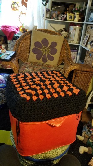 Recovering an Old Hassock - hassock top covered with a large black and orange granny square