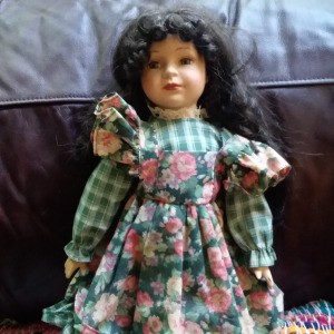 Identifying a Porcelain Doll - doll wearing a plaid dress with a floral apron