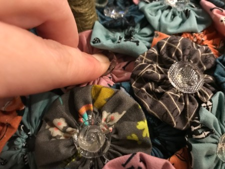 Yo Yo Covered Papier-mâché Pumpkins - gluing on clear buttons of differing shapes