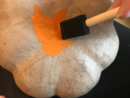 Yo Yo Covered Papier-mâché Pumpkins - painting the bottom of the pumpkin orange using a foam brush