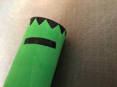 Cardboard Halloween Napkin Rings - zig zag hair drawn with marker and a slanted black rectangle for an eye brow