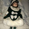 Identifying Porcelain Dolls - doll wearing a dark green velvet dress and matching hat trimmed in white fur