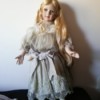 Identifying a Porcelain Doll - doll in old style dress with embroidery on the bottom