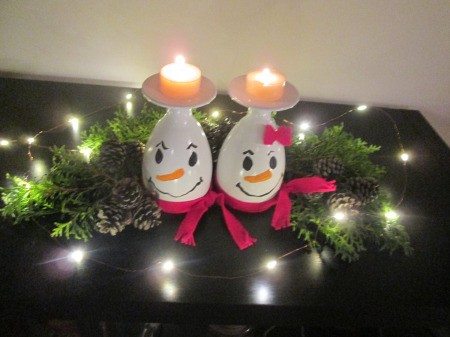 Drinking Glass Candle Holders - candleholders surrounded with greenery and string of white lights