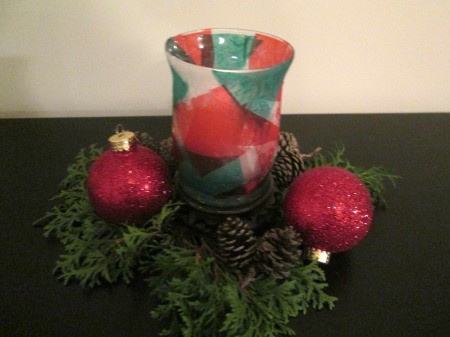 DIY Stained Glass Candle Holder - finished holder surrounded by greenery and red ornaments