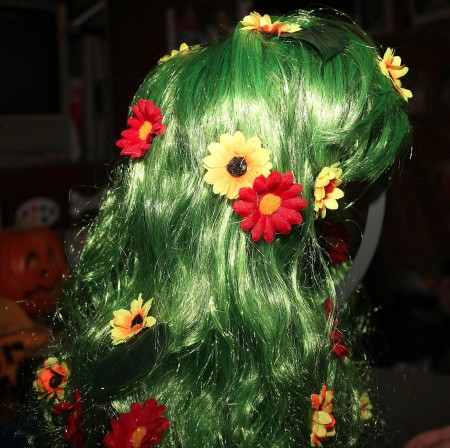 Attaching flowers to a green wig.